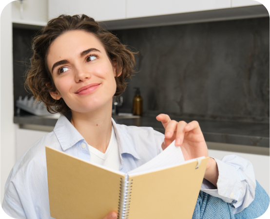 
						la niña está leyendo un cuaderno