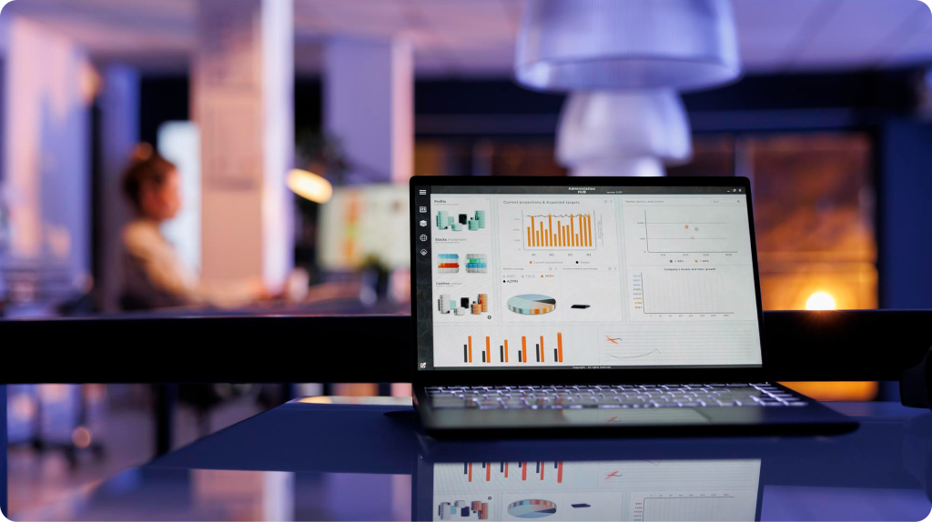 Laptop que muestra un panel de métricas con gráficos de ingresos y proyecciones