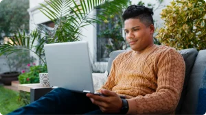 Freelancer latinoamericano trabaja con su laptop desde el patio de su casa